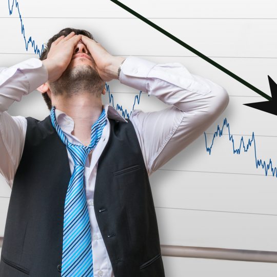 Bad investment or economic crisis concept. Businessman is disappointed from losing in stock exchange. Chart with arrow down on whiteboard in background.